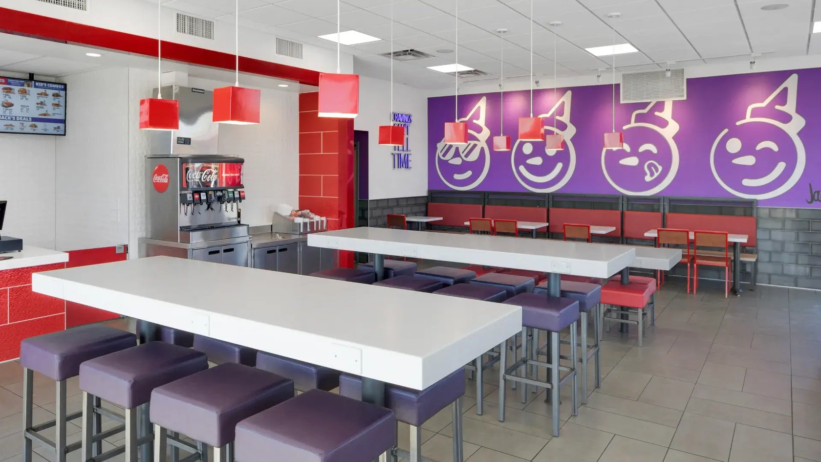 Jack in the Box CRAVED interior dining room with emoji mural wall and communal high-top seating