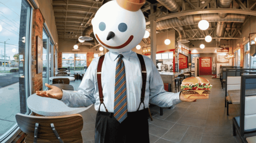 Jack Box holding a Jumbo Jack Cheeseburger